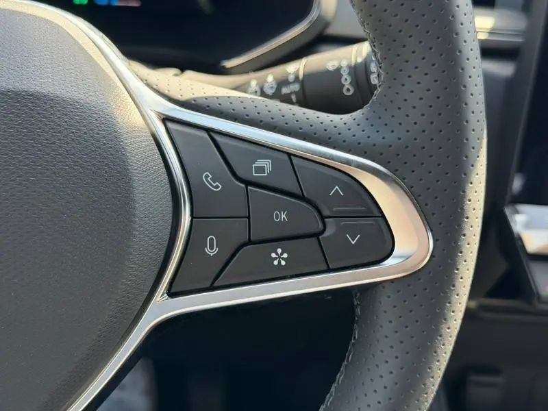 Gros plan sur les commandes multifonctions en cuir perforé du volant du Renault Captur gris Rafale 2026.