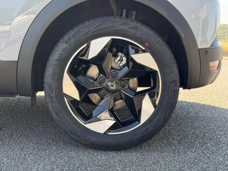 Gros plan sur la roue avant droite du Renault Captur 2026 gris Rafale, jante alu noire et argentée au design géométrique.