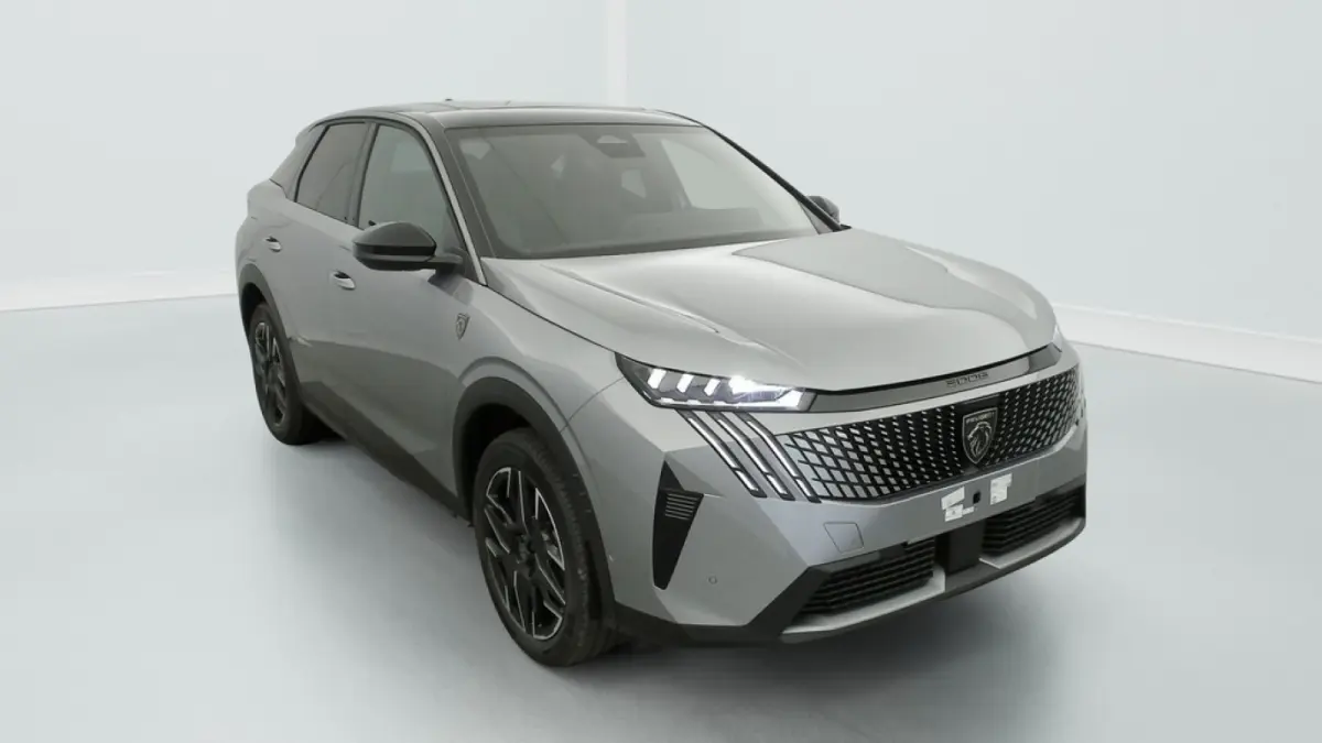 Peugeot 3008 1.2 Hybrid 145 GT gris, vue 3/4 avant avec calandre distinctive et phares LED allumés.
