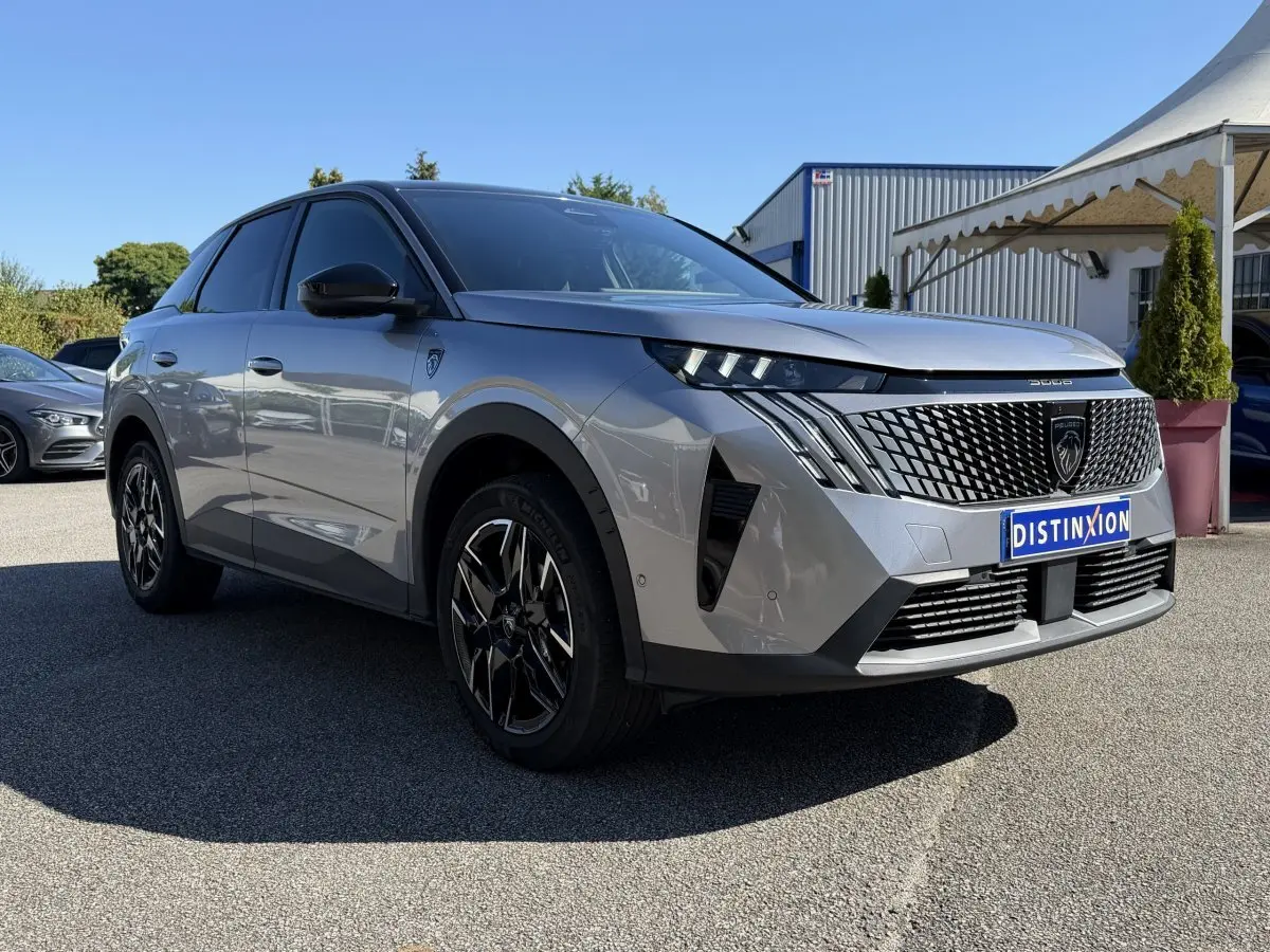 Peugeot 3008 gris clair en 3/4 avant droit, avec calandre noire distinctive et jantes alliage noires.