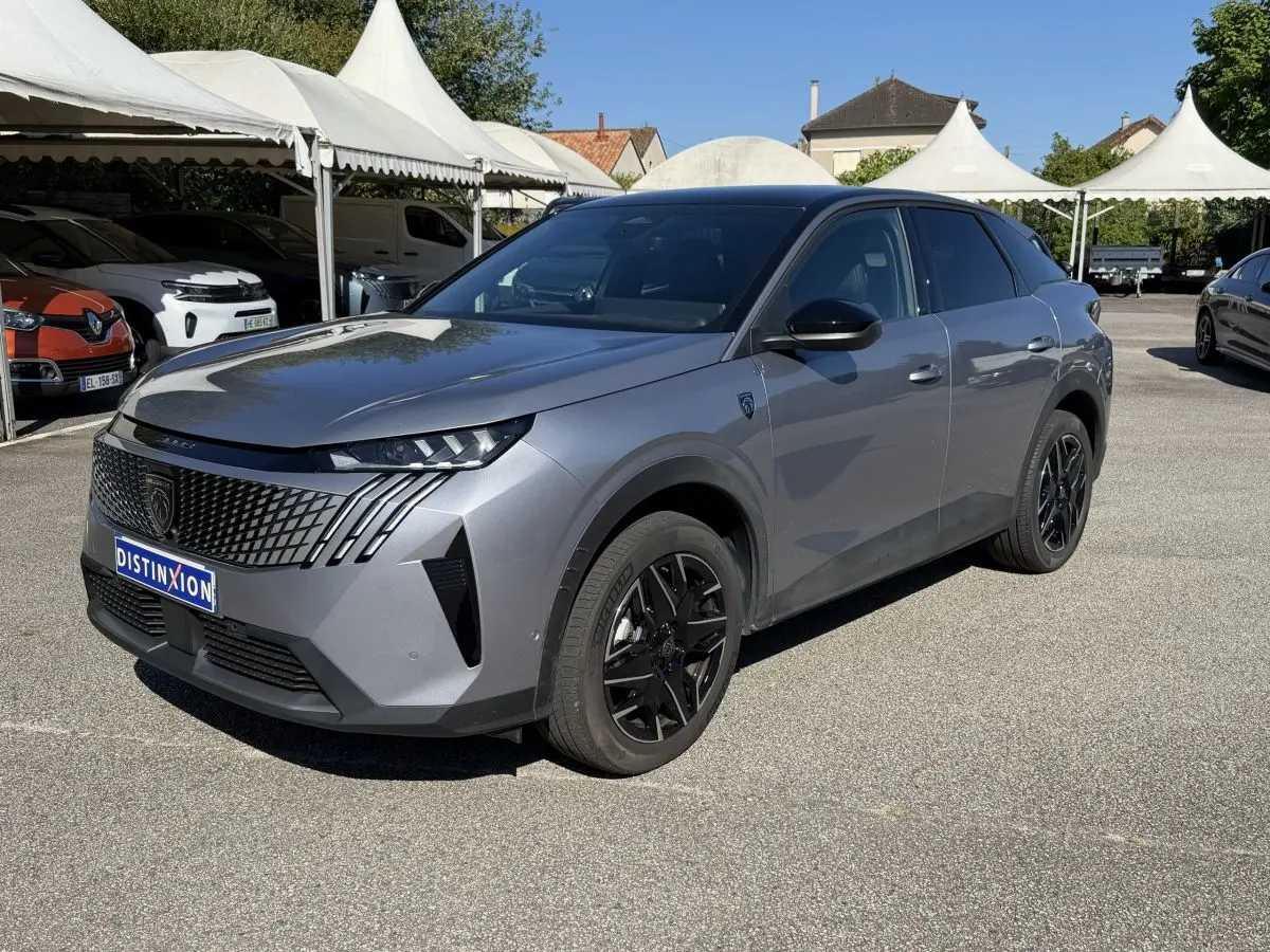 Peugeot 3008 gris clair en 3/4 avant droit, avec calandre distinctive et jantes noires brillantes.