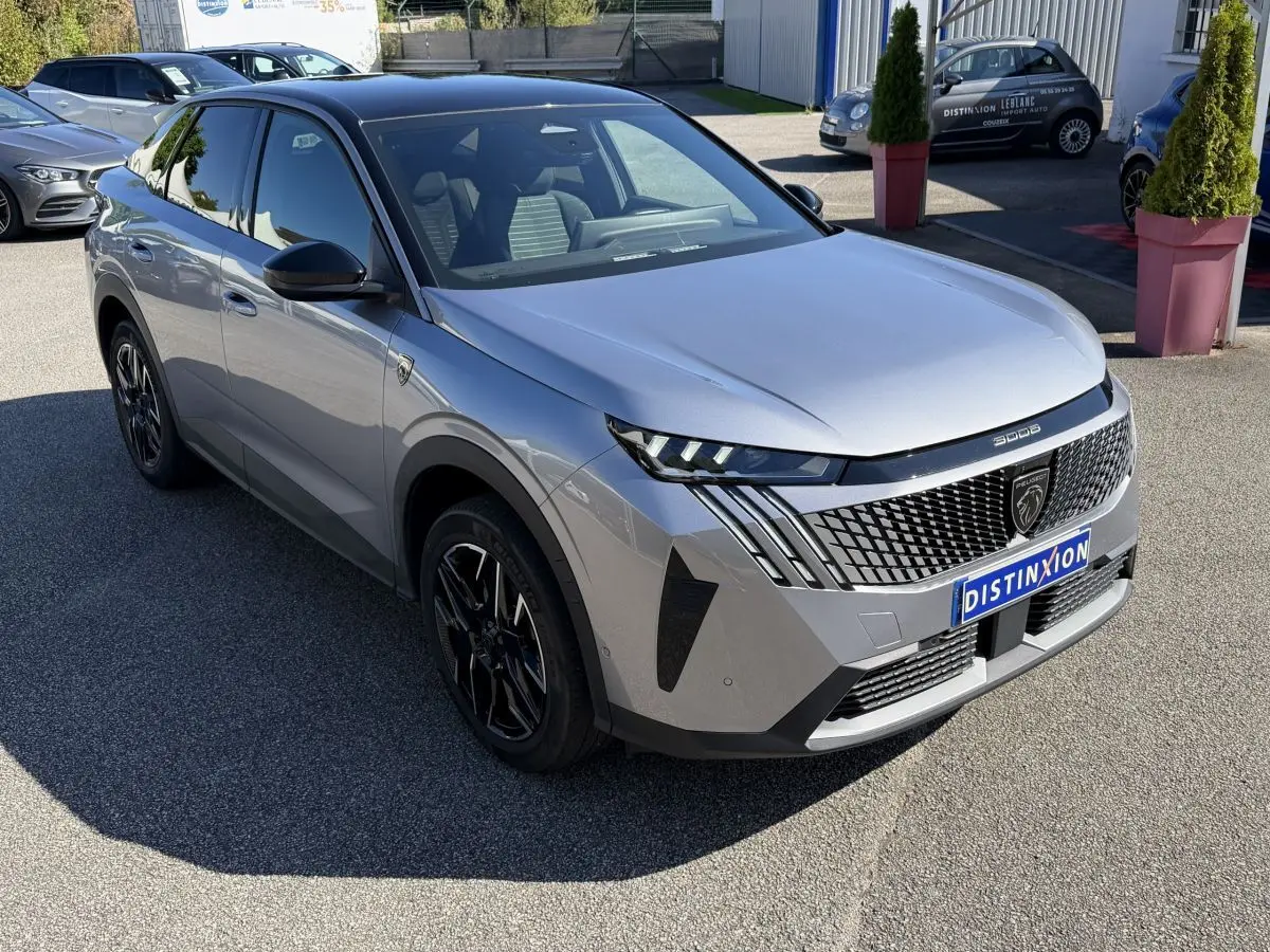 Peugeot 3008 gris clair vue 3/4 avant droit, avec calandre distinctive et jantes noires stylisées.