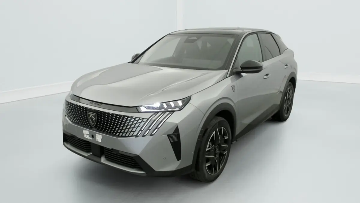 Peugeot 3008 hybride 2025 gris clair en 3/4 avant droit avec calandre noire et phares LED allumés.