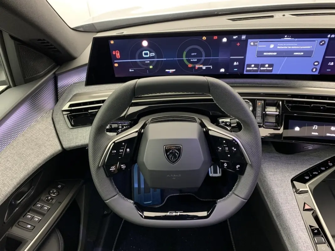 Vue intérieure centrée sur le volant cuir GT et l'écran tactile large du tableau de bord du Peugeot 3008 hybride 2025.