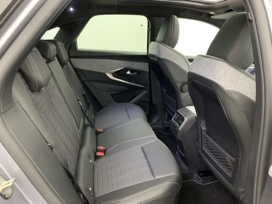 Vue intérieure arrière côté gauche du Peugeot 3008 2025 avec sièges en cuir noir et tissu gris clair.