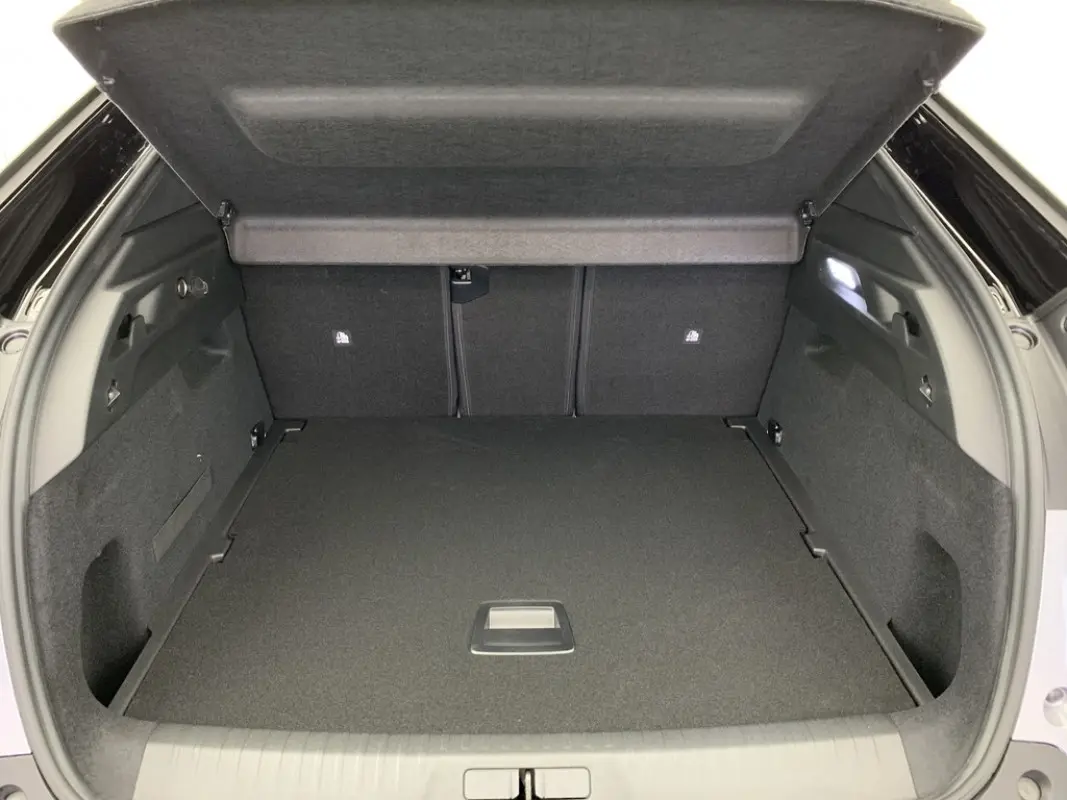 Coffre ouvert du Peugeot 3008 1.2 Hybrid 145 GT vu de l'arrière, intérieur noir et espace de rangement spacieux.