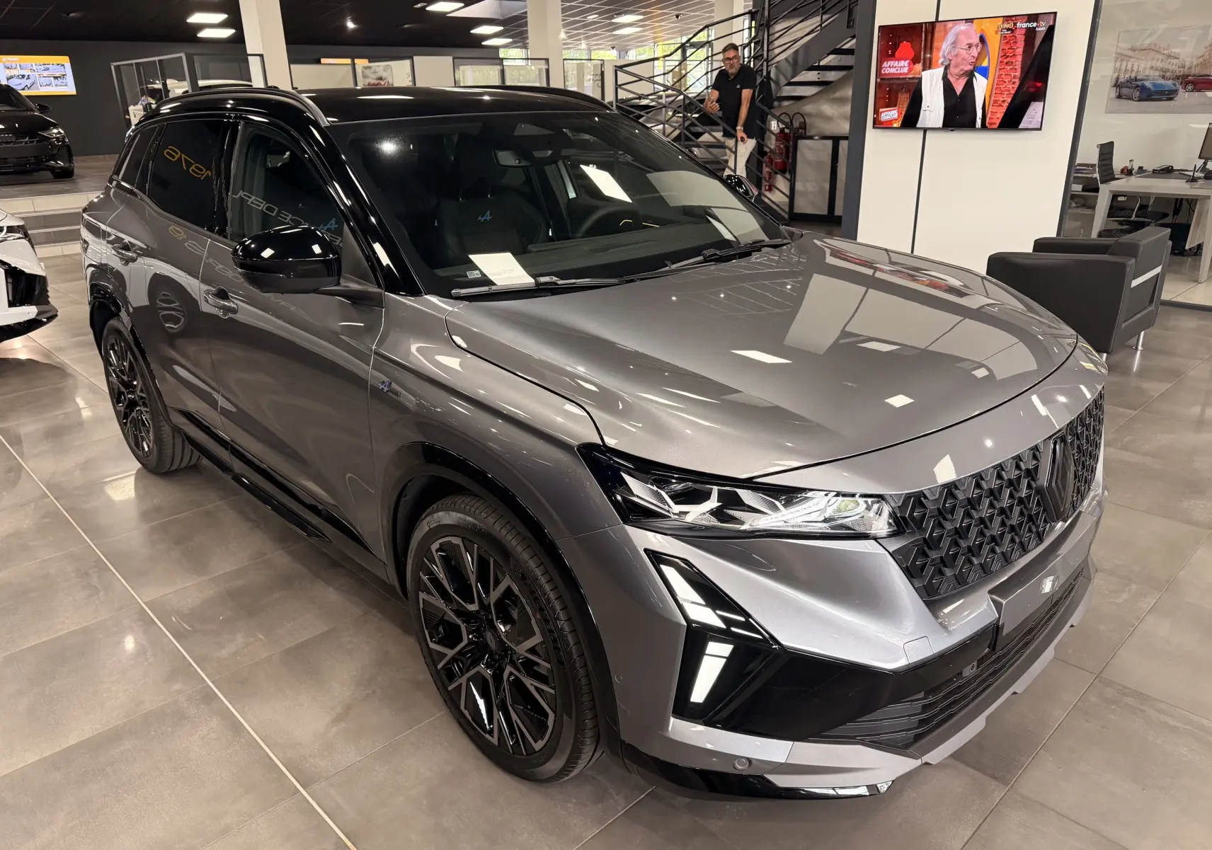 Renault Austral full hybrid gris schiste avec toit noir, vue 3/4 avant mettant en valeur ses optiques LED et jantes noires.