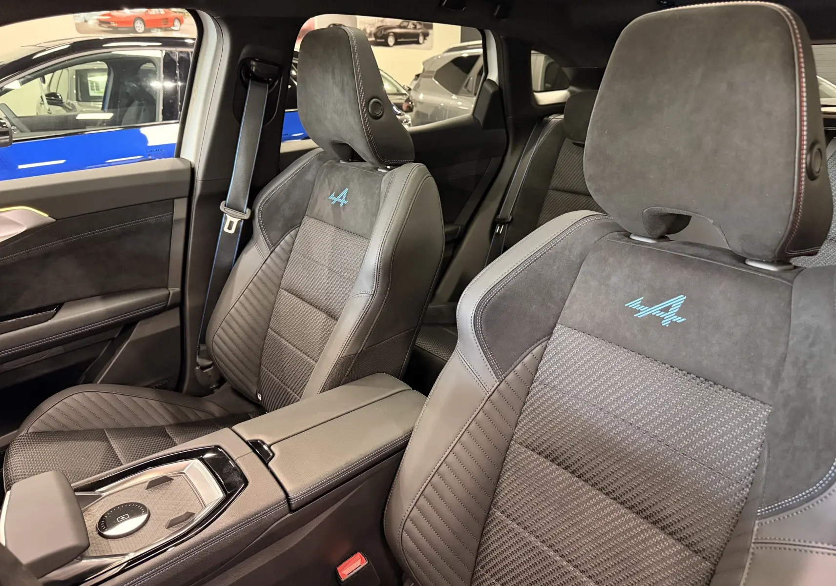 Vue intérieure rapprochée des sièges avant en cuir noir avec logo Alpine bleu sur Renault Austral 2026.