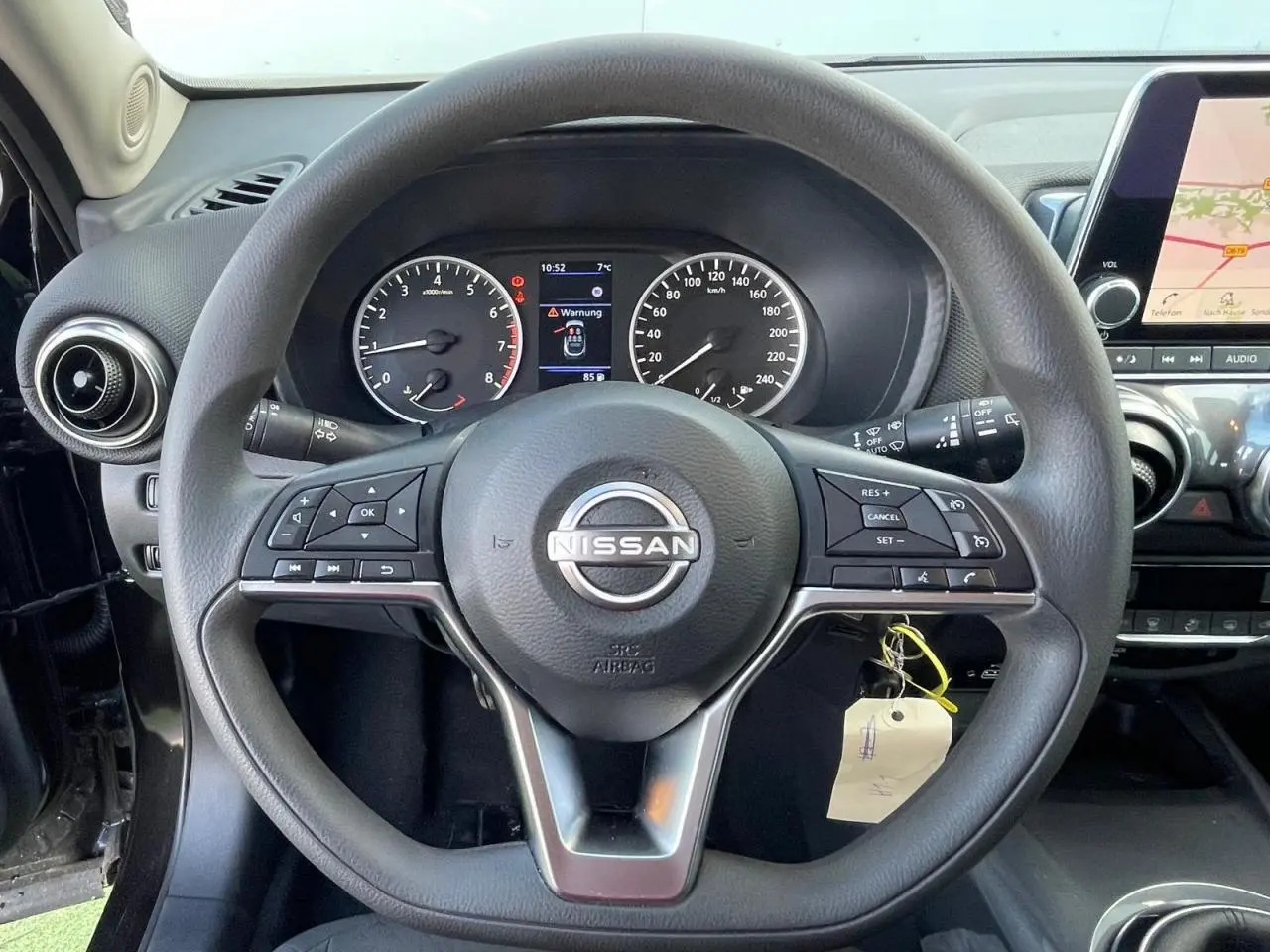 Vue rapprochée du volant noir de Nissan Juke 2024 avec tableau de bord digital et écran tactile de navigation.