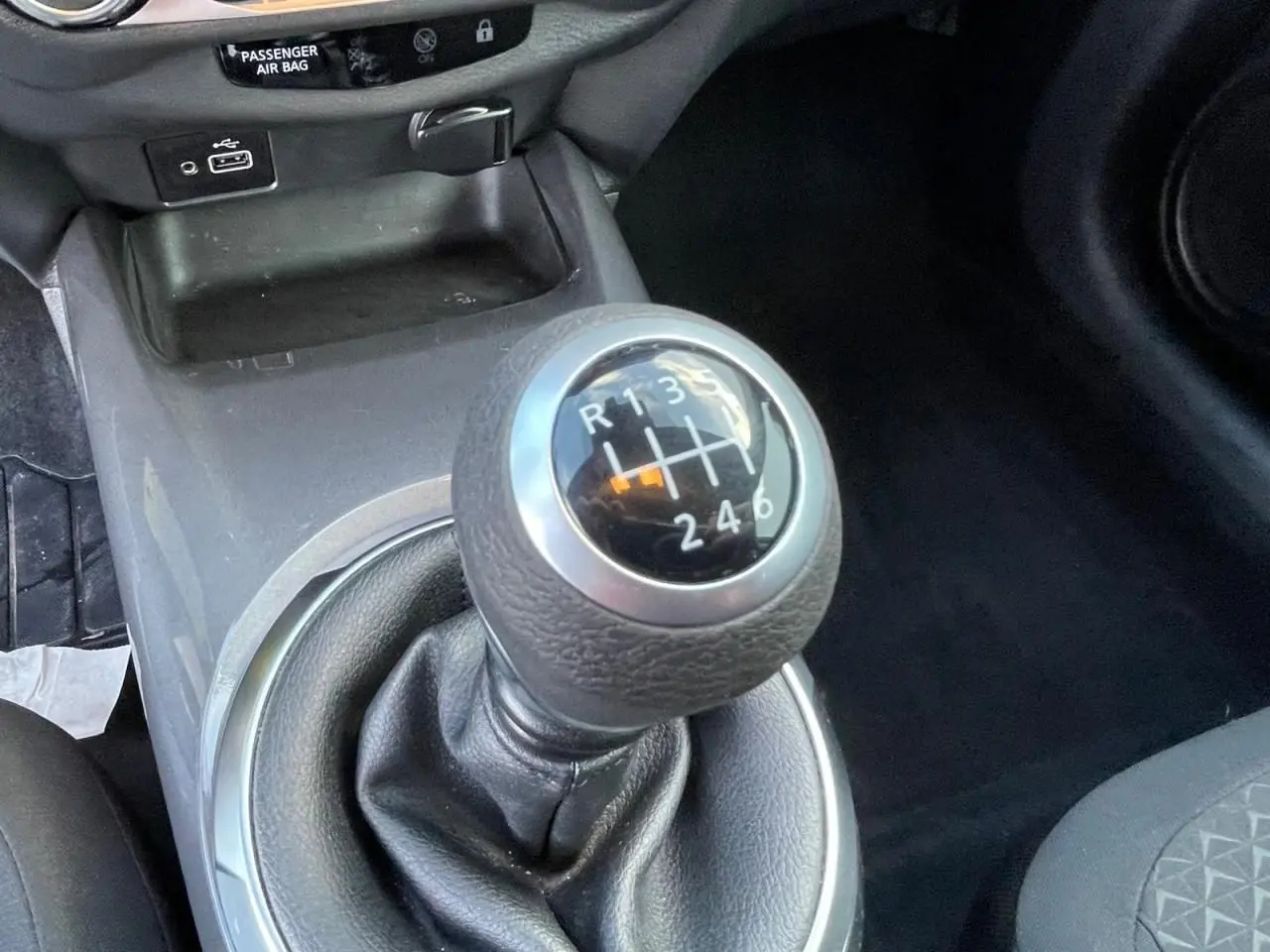 Le levier de vitesses manuel noir du Nissan Juke 2024, avec indication des six rapports et marche arrière.