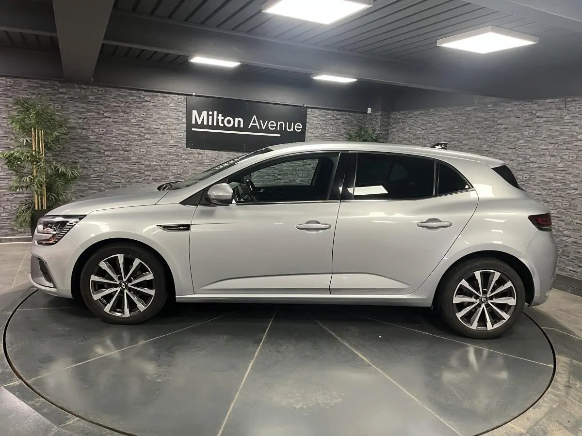 Profil droit d'une Renault Mégane gris Highland 2022 en finition R.S. Line, avec jantes alliage 17 pouces et antenne aileron de requin.