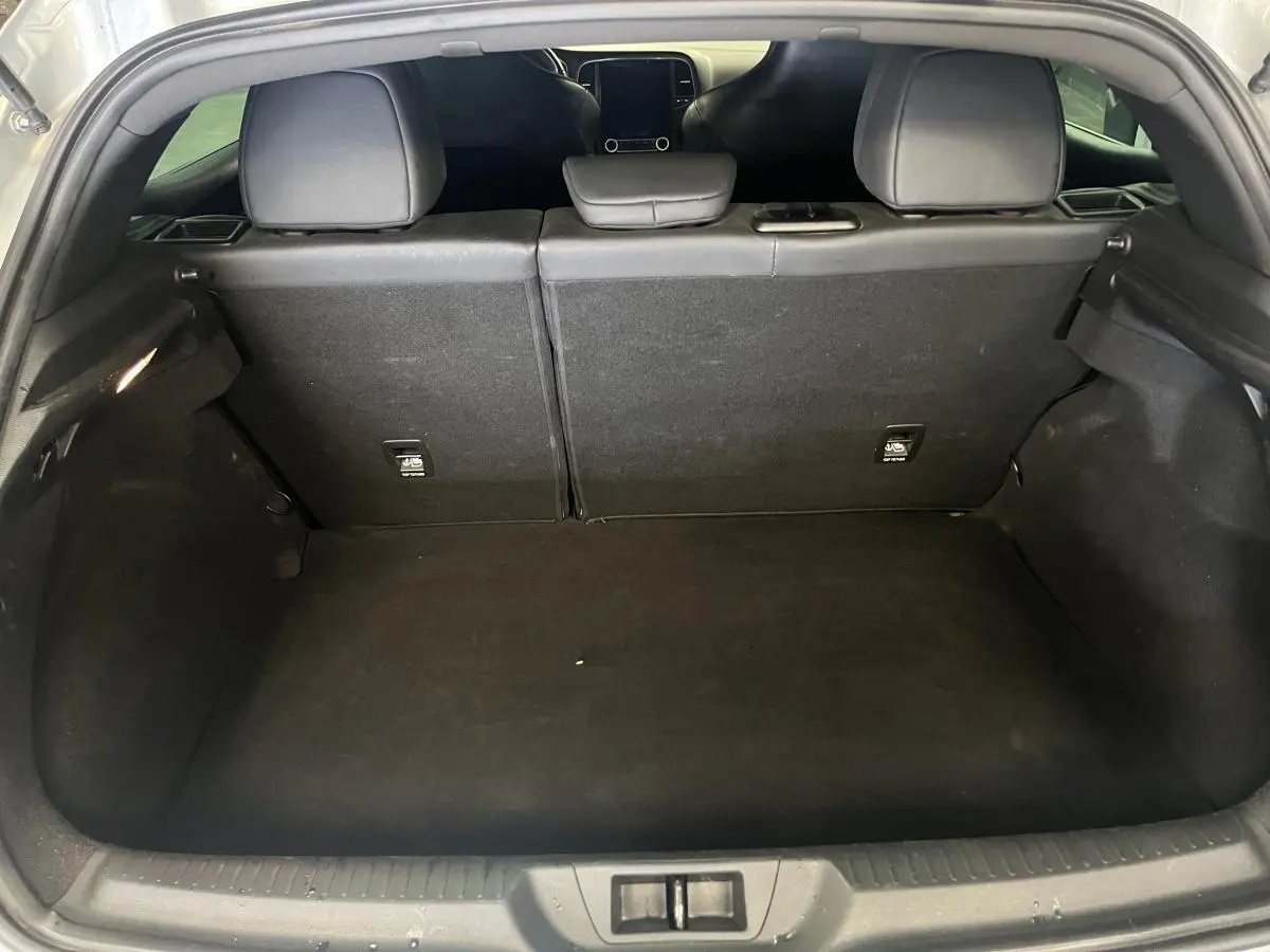 Coffre ouvert de la Renault Mégane gris, vue arrière montrant l'espace de chargement et les dossiers de sièges rabattables.