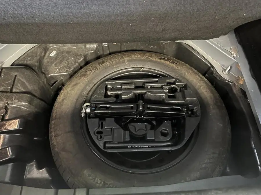 Roue de secours avec outillage intégré dans le coffre d'une Renault Mégane gris Highland 2022.