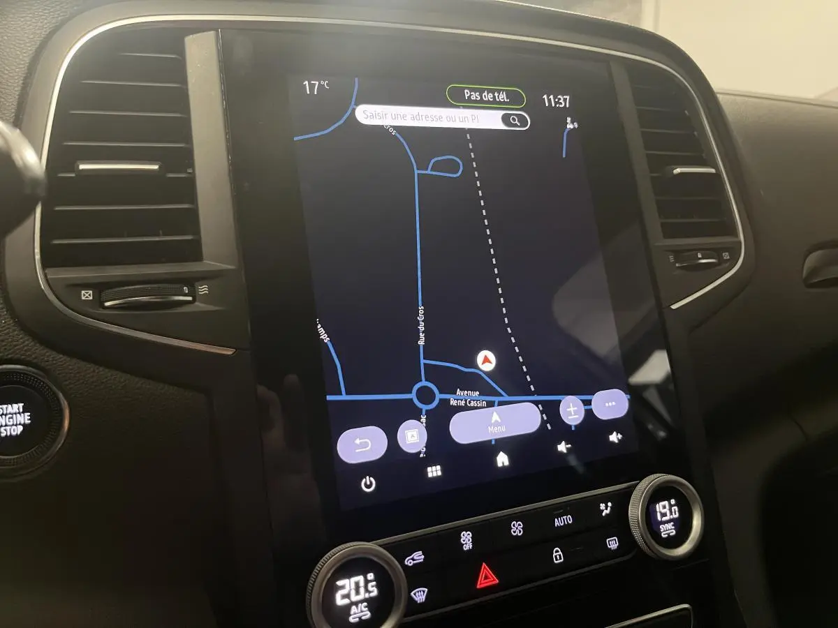Tableau de bord de Renault Mégane gris 2022 avec écran tactile 10'' affichant navigation et commandes climatisation.