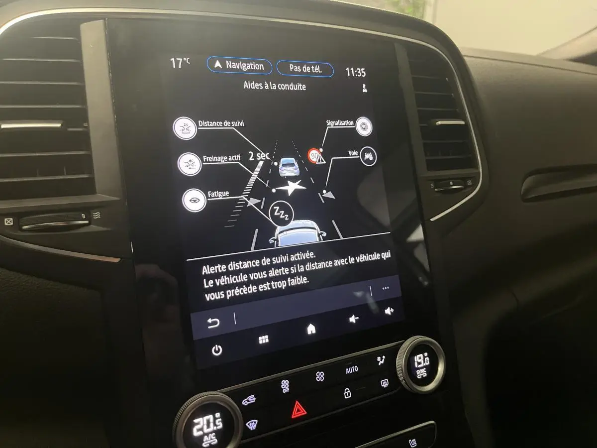 Écran tactile central de la Renault Mégane R.S. Line 2022 affichant les aides à la conduite dans un intérieur noir.