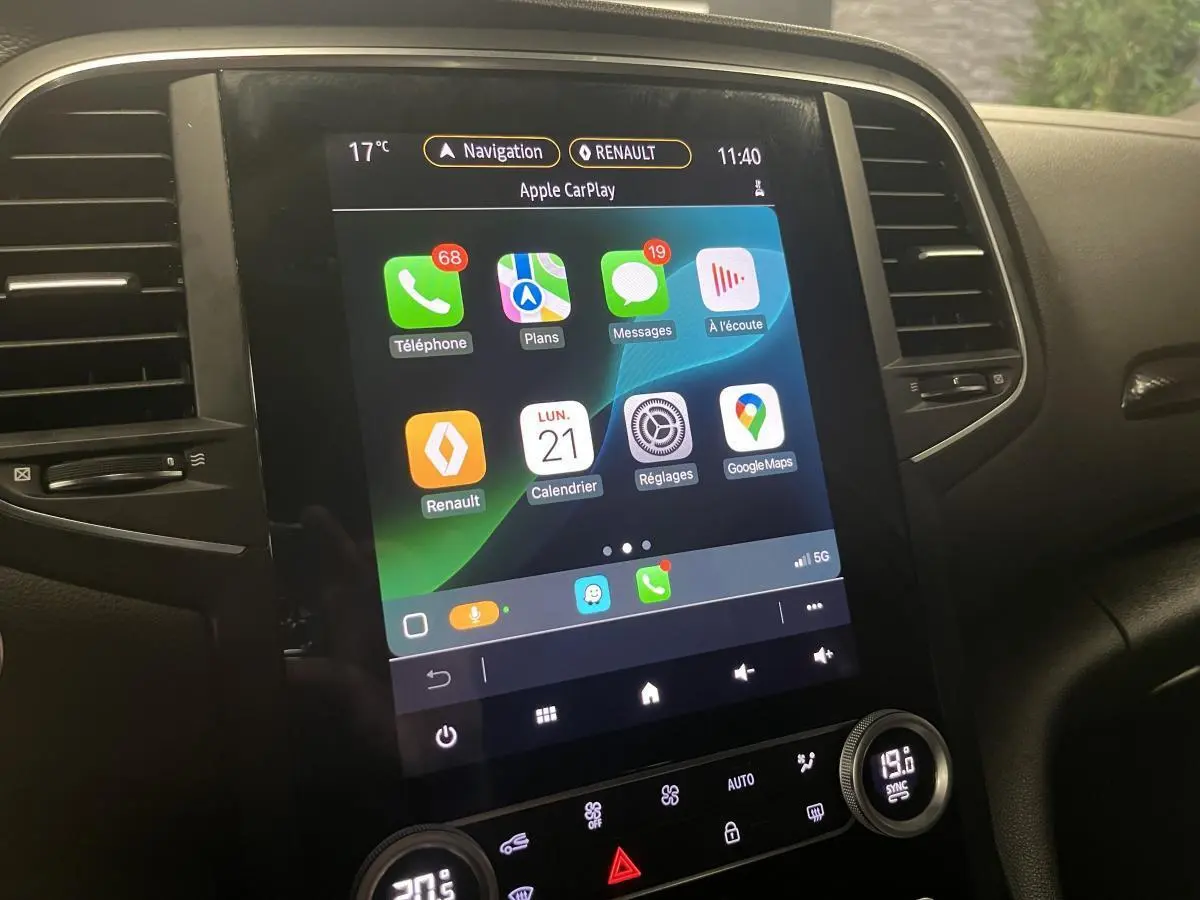 Écran tactile multimédia Renault Mégane 2022 affichant Apple CarPlay, entouré de commandes noires du tableau de bord.
