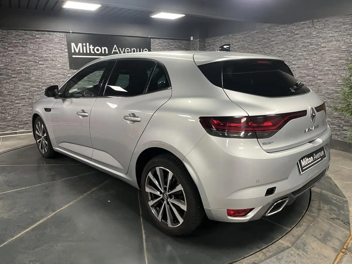 Renault Mégane gris Highland vue 3/4 arrière droit avec feux LED et double sortie d’échappement chromée.