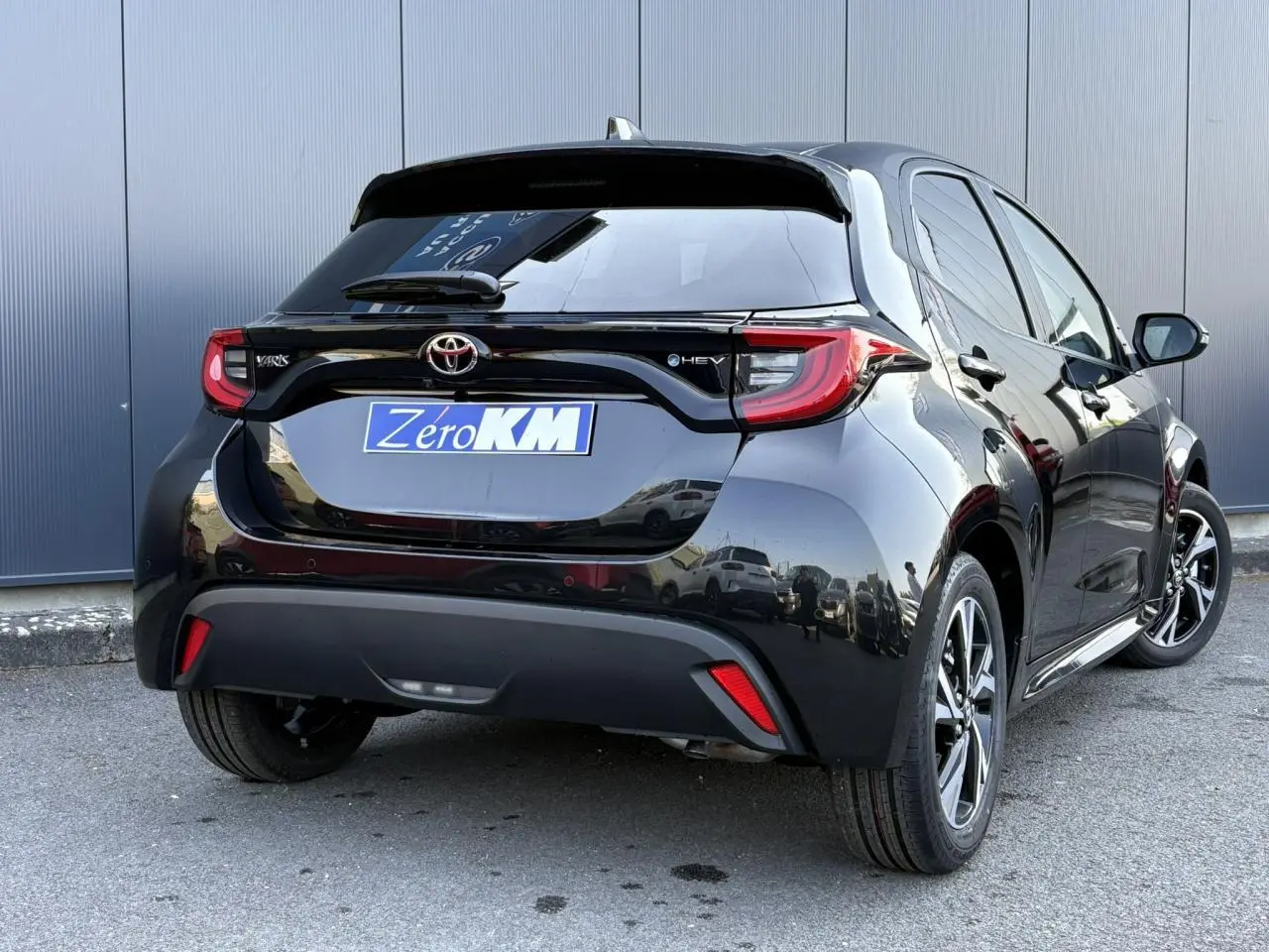 Vue 3/4 arrière droite d'une Toyota Yaris Hybride 2025 noir intense avec feux arrière LED et jantes alliage 16 pouces.