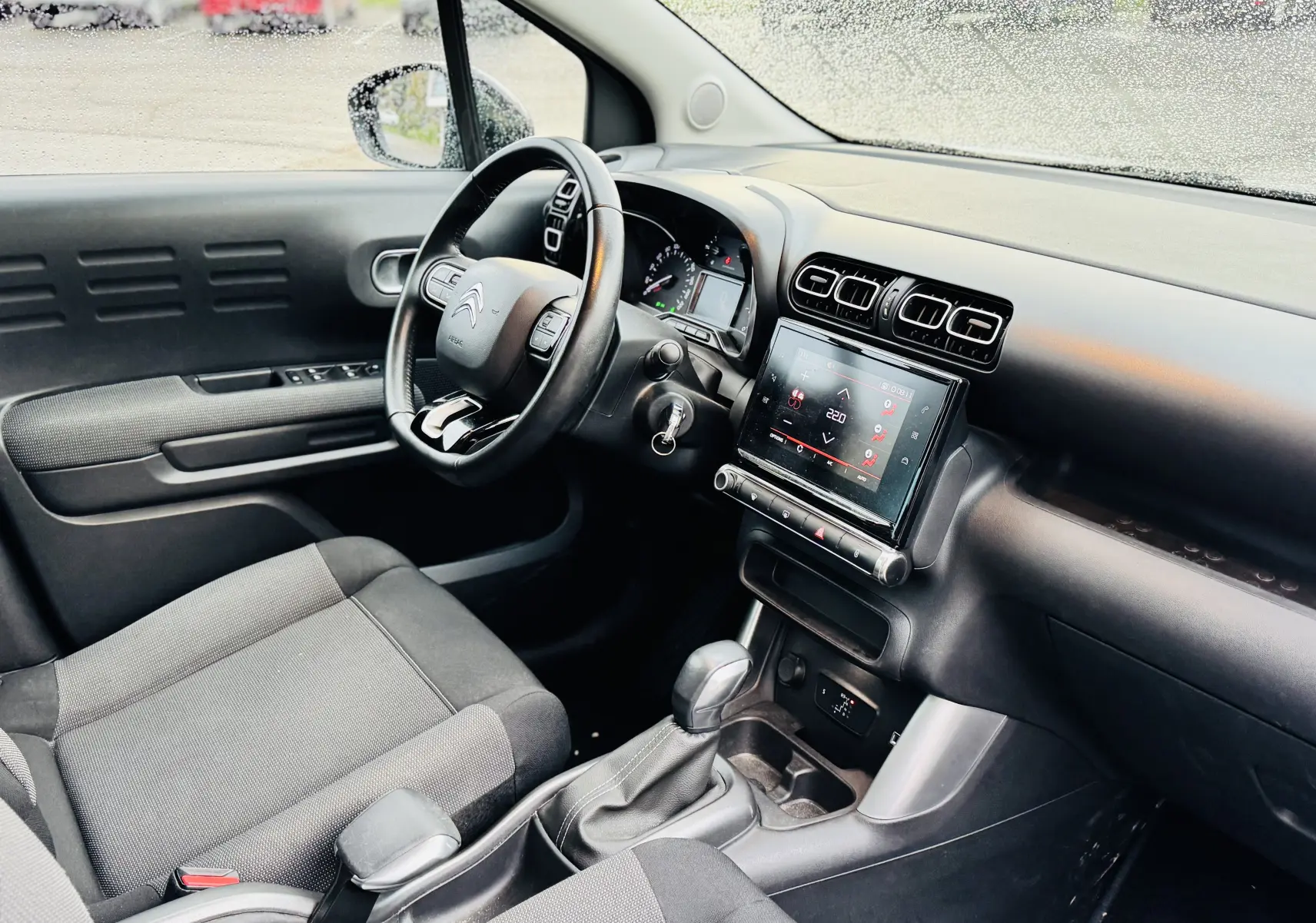 Intérieur avant droit de la Citroën C3 Aircross gris avec tableau de bord moderne et écran tactile central.
