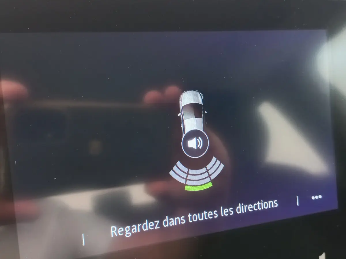 Affichage écran tactile montrant le capteur de distance arrière actif sur Renault Clio Business blanc, vue intérieure.