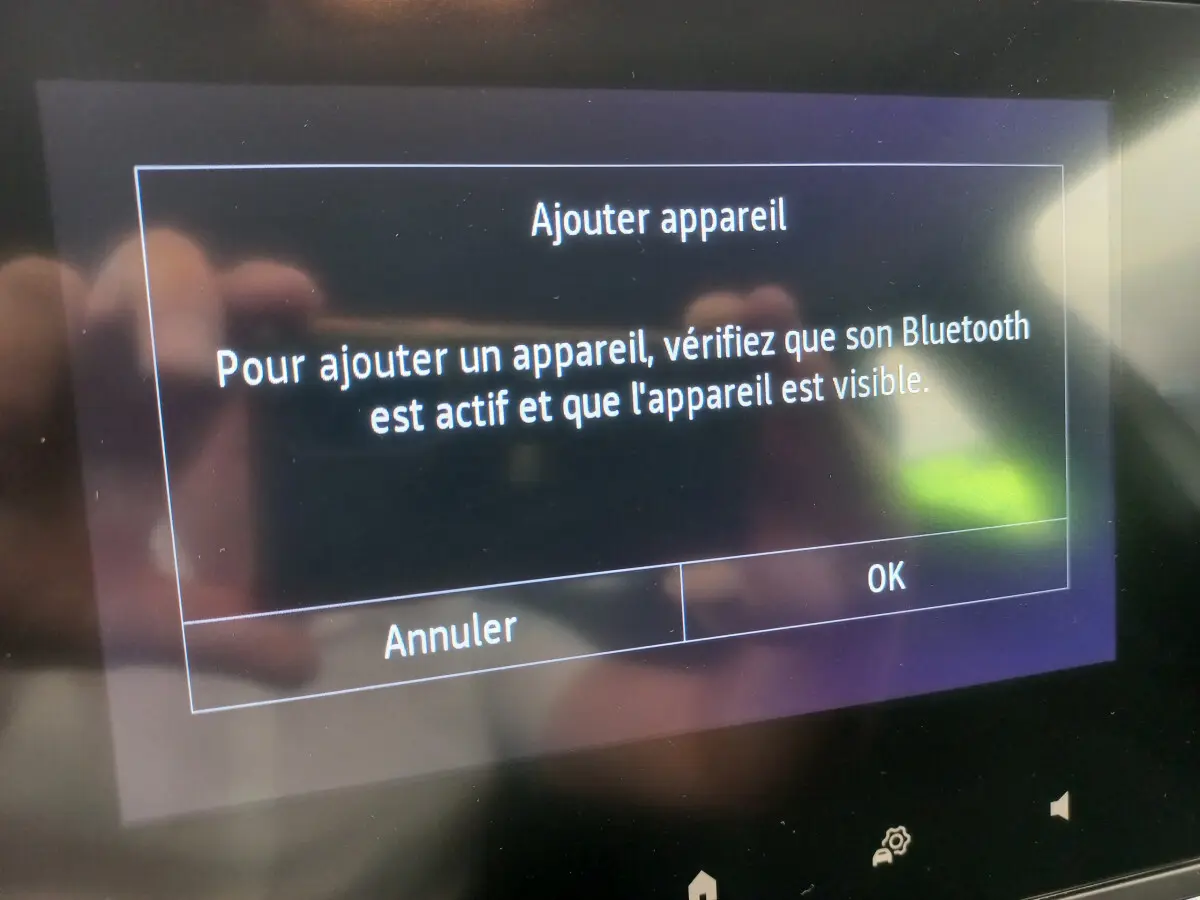 Écran tactile central de la Renault Clio Business blanc 2021 affichant un message d'ajout Bluetooth.