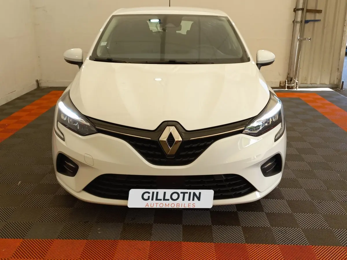 Vue avant d'une Renault Clio Business blanche avec phares LED allumés et calandre noire brillante.