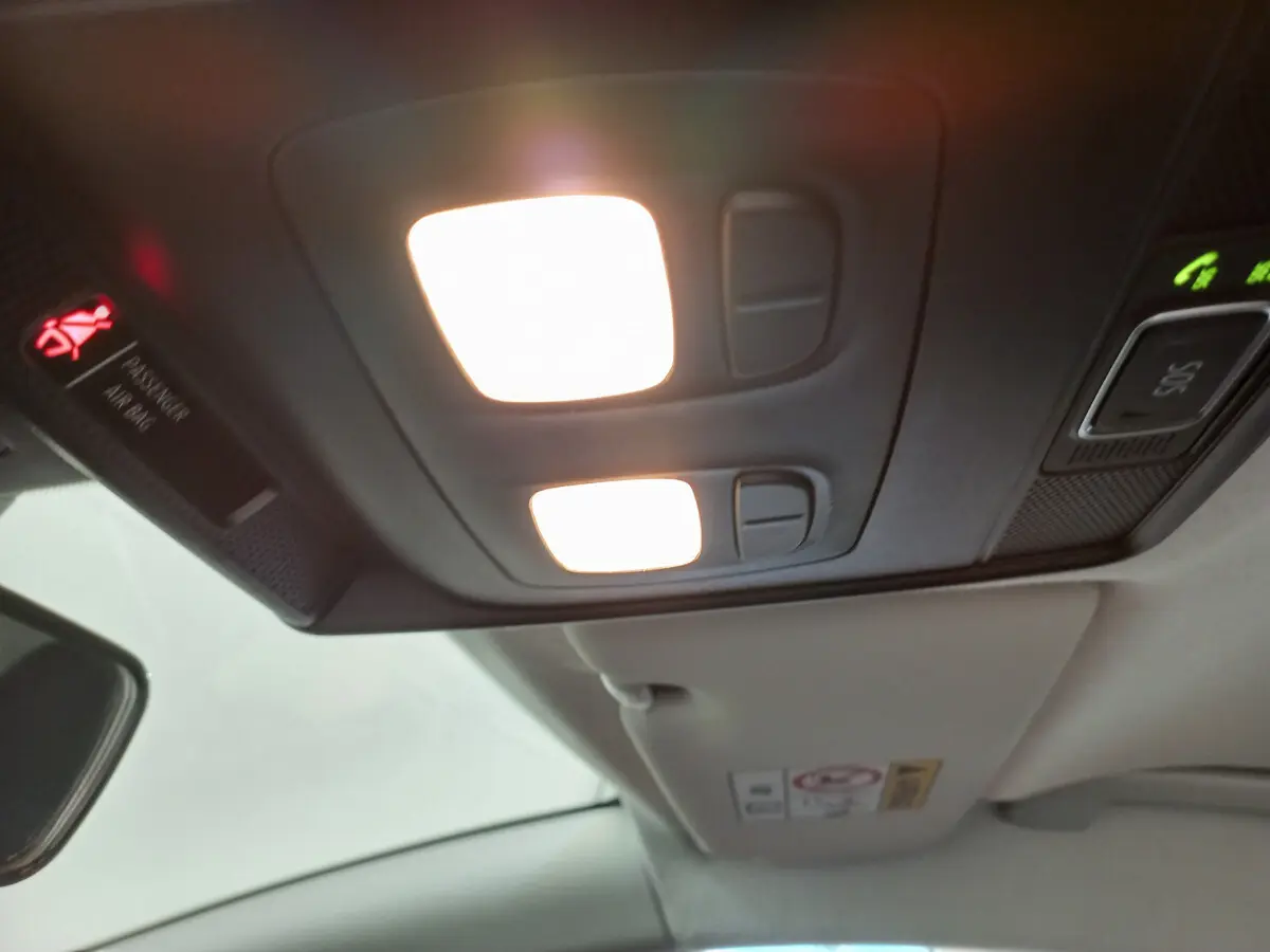 Plafonnier intérieur allumé avec commandes et panneau de signalisation dans une Renault Clio Business blanche de 2021.