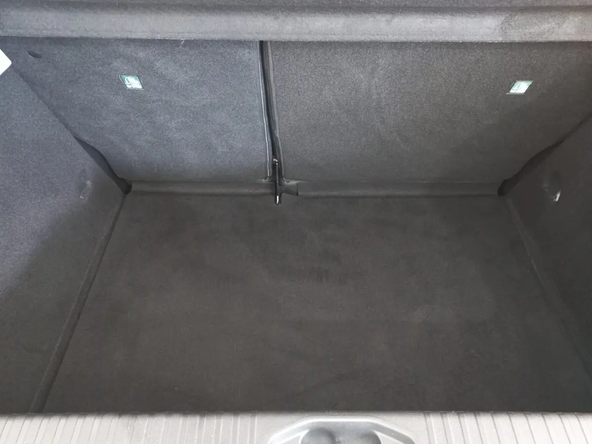 Coffre vide de la Renault Clio Business blanche 2021, vue plongeante sur l'espace de chargement avec banquette arrière rabattue.