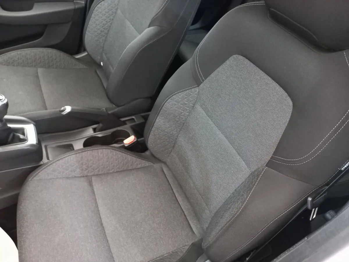 Gros plan sur les sièges avant gris foncé de la Renault Clio Business SCe 65, montrant la texture et les coutures.