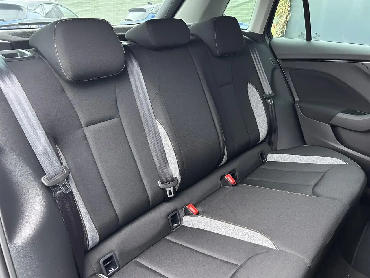 Vue latérale droite des sièges arrière en tissu noir et gris clair du Skoda Kamiq gris graphite 2025.