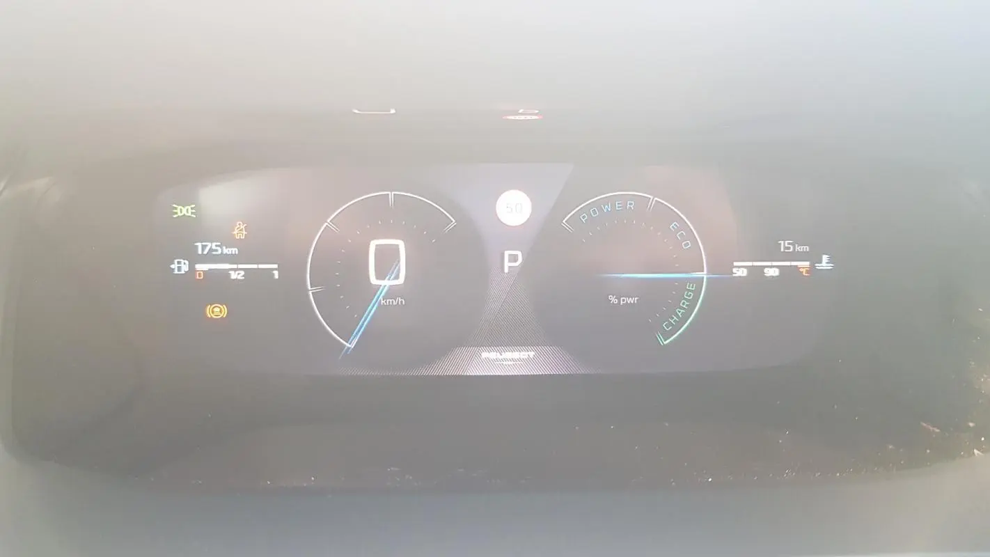 Tableau de bord numérique de la Peugeot 208 Hybrid 110 GT affichant la vitesse, autonomie et indicateurs d'énergie.