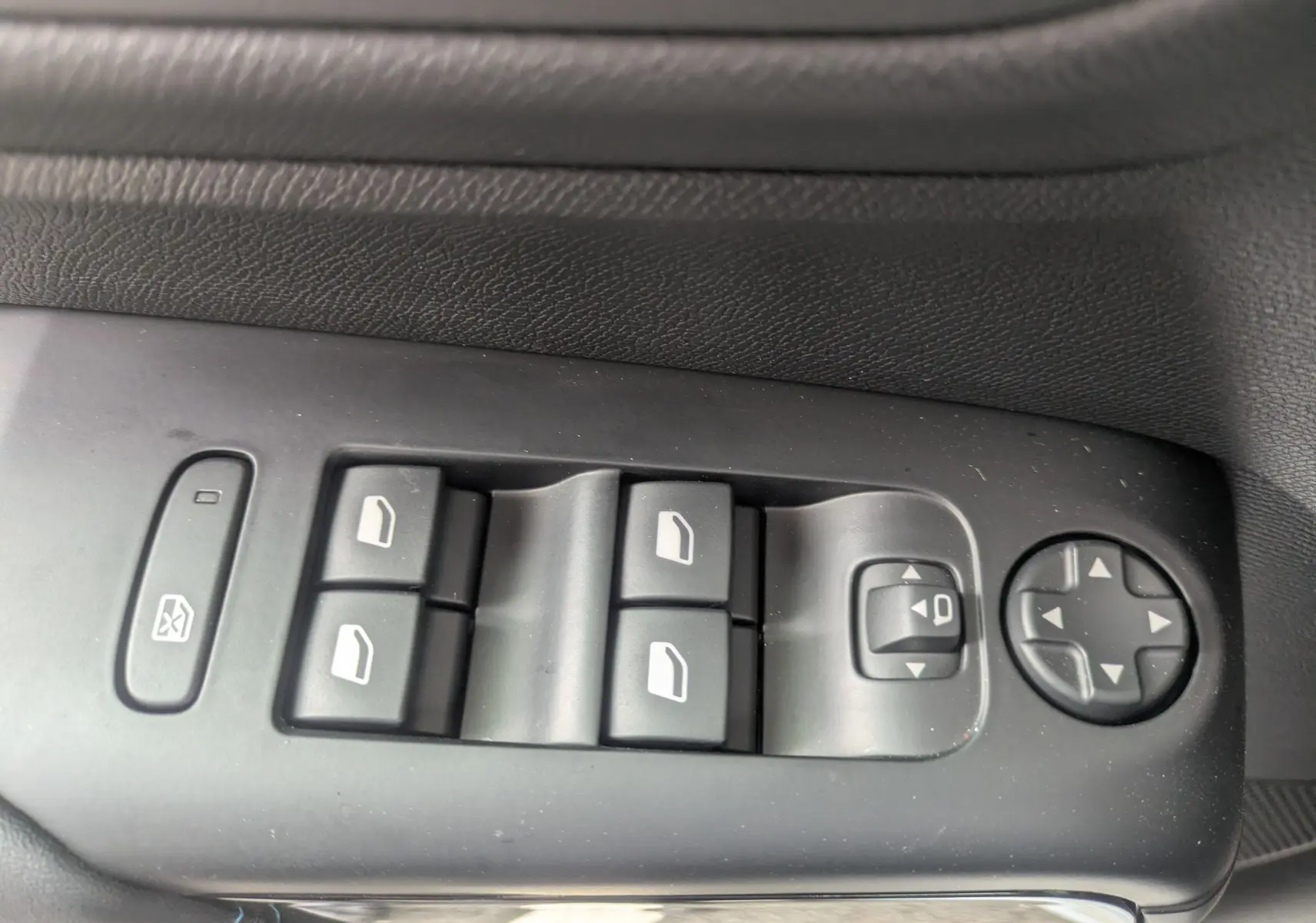 Gros plan sur les commandes de lève-vitres et réglage des rétroviseurs côté conducteur d'une Citroën C5 Aircross blanche.