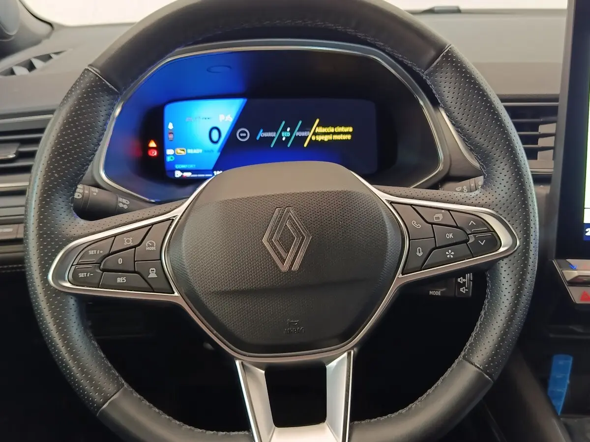 Vue rapprochée du volant cuir noir perforé de la Renault SYMBIOZ avec tableau de bord numérique lumineux en arrière-plan.
