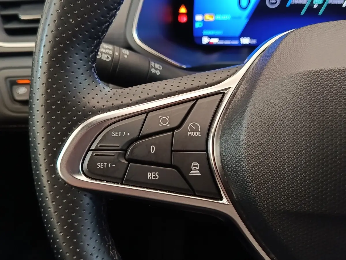 Gros plan sur les commandes multifonctions côté gauche du volant noir perforé de la Renault Symbioz 2025.