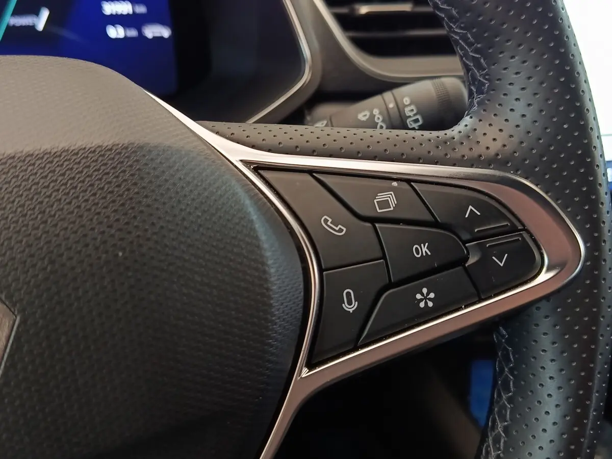 Gros plan sur les commandes multifonctions à droite du volant noir perforé du Renault SYMBIOZ 2025.