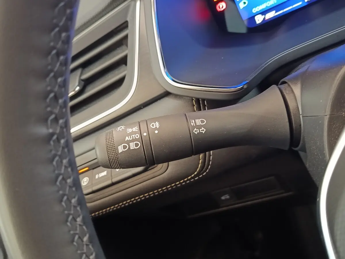 Gros plan sur la commande des phares et clignotants côté gauche du volant du Renault Symbioz noir, intérieur moderne.