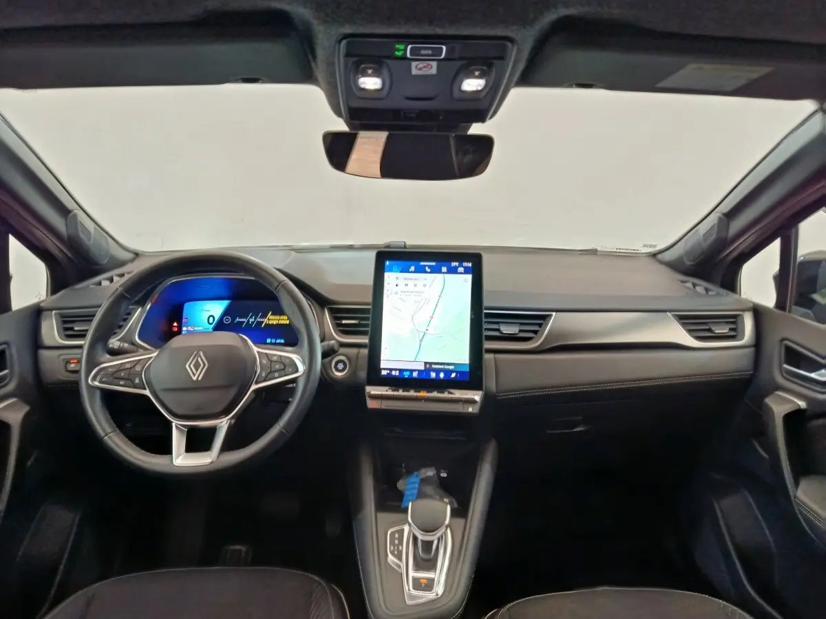 Vue intérieure avant du tableau de bord noir du Renault SYMBIOZ avec écran tactile vertical et volant multifonctions.