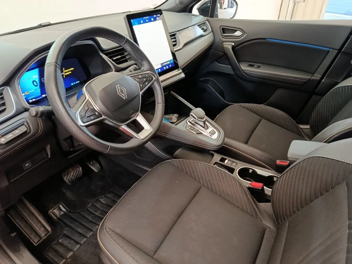 Vue intérieure côté conducteur de la Renault SYMBIOZ noire, avec volant multifonctions et grand écran tactile vertical.