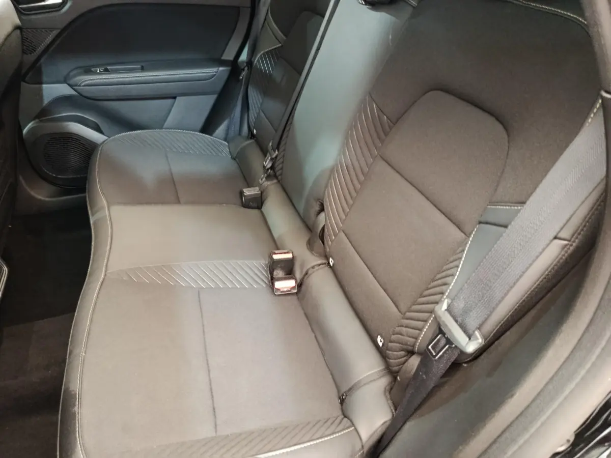 Vue intérieure côté droit sur la banquette arrière noire du Renault Symbioz 2025 avec ceinture et porte de porte visible.