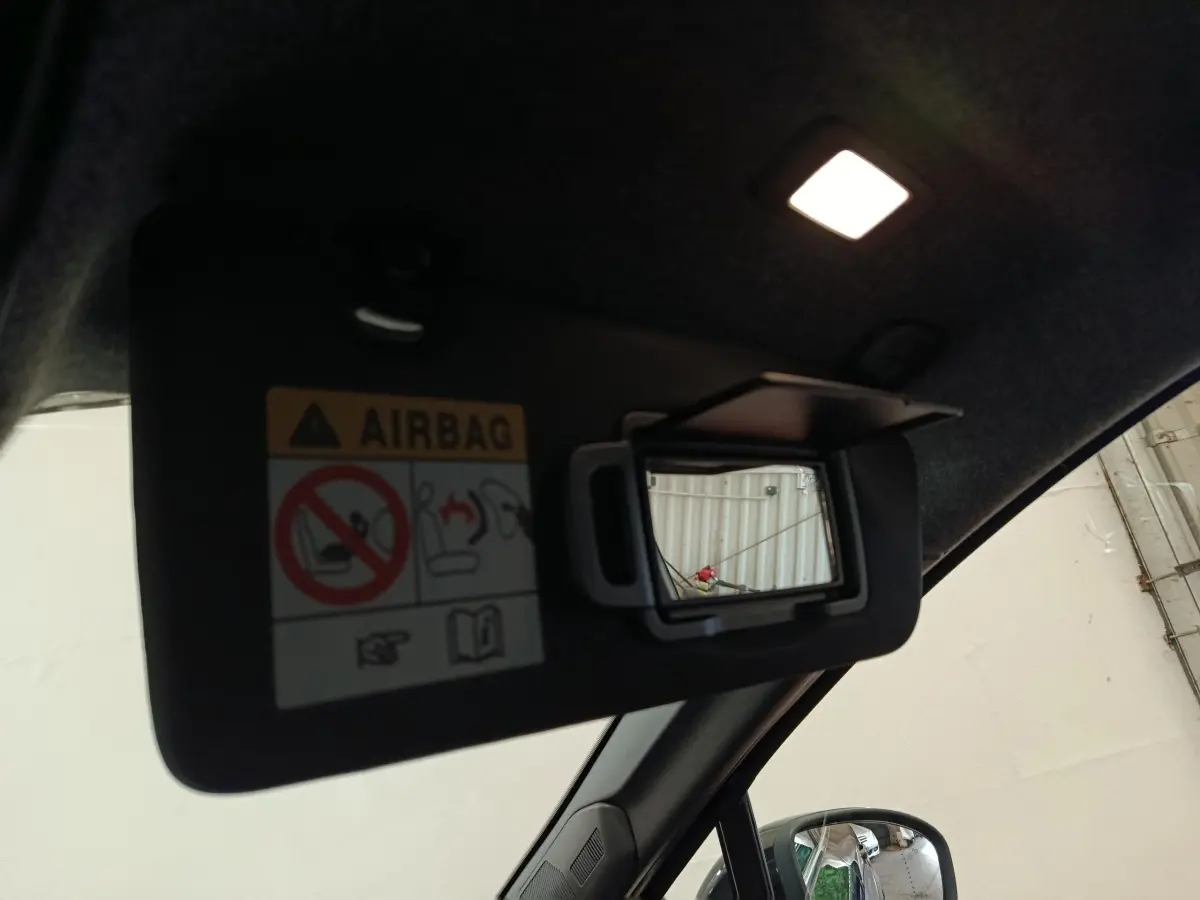 Détail du pare-soleil côté conducteur avec miroir de courtoisie ouvert dans un Renault Symbioz noir, vue intérieure.