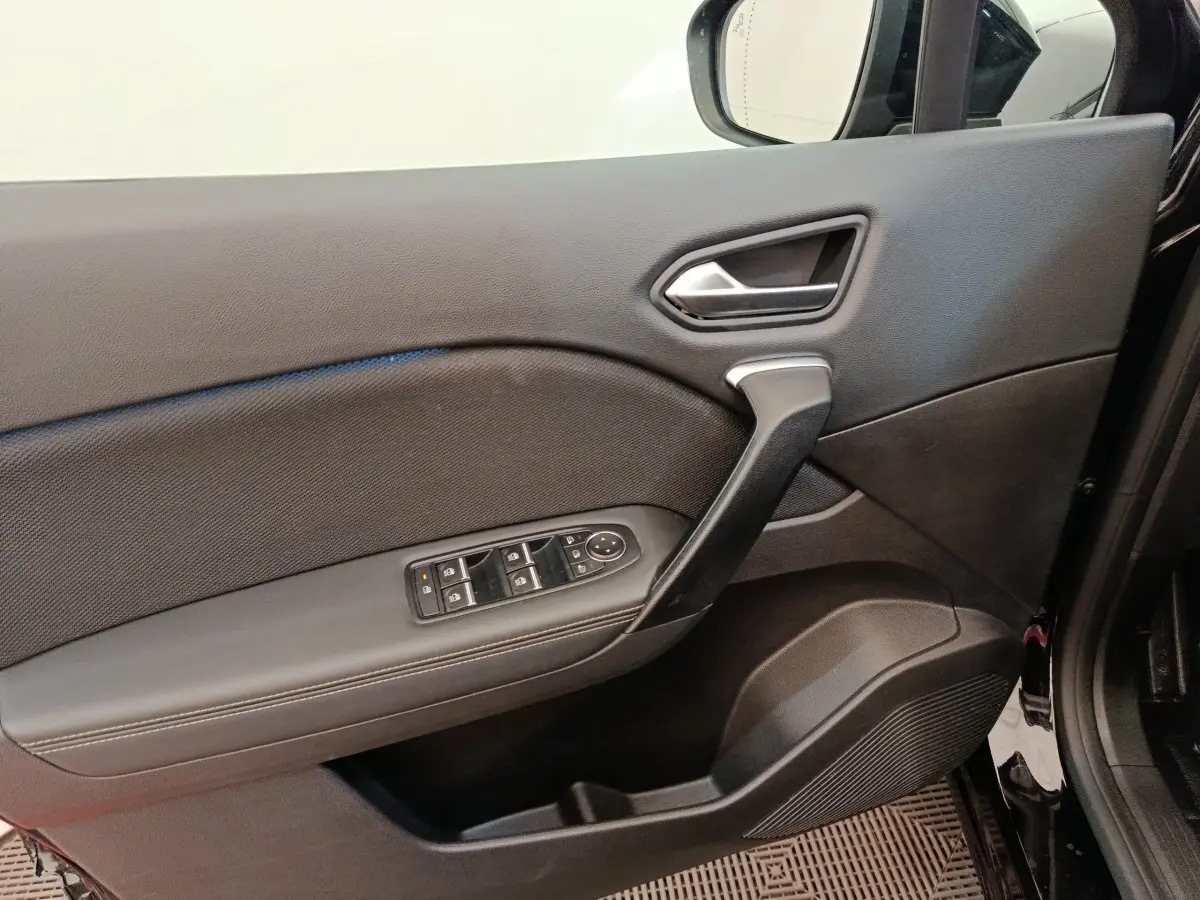 Vue intérieure du panneau de porte avant gauche noir du Renault Symbioz avec commandes électriques des vitres et rétroviseurs.