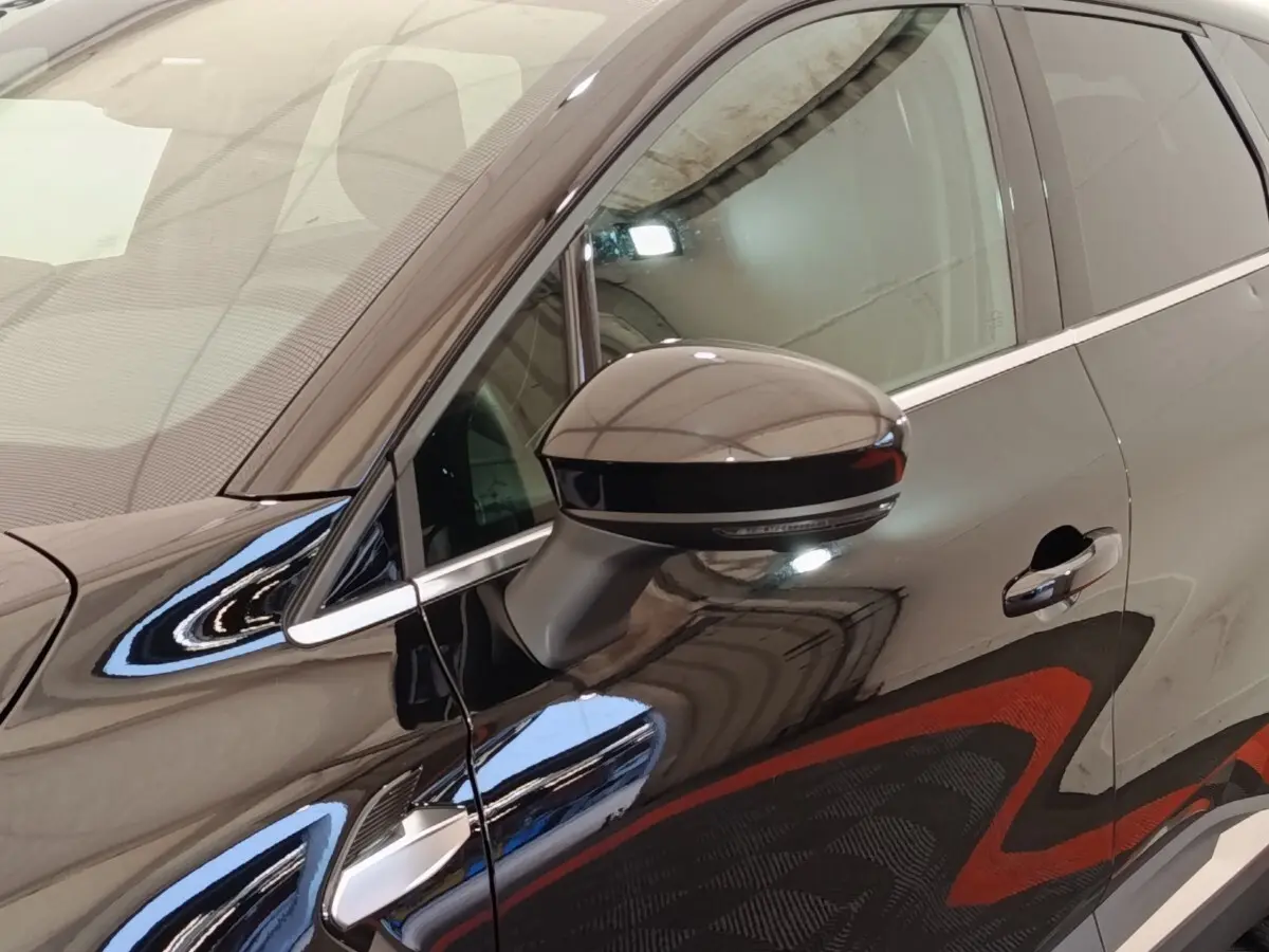 Détail du rétroviseur côté gauche d’une Renault Symbioz noire avec poignée de porte et vitre avant visibles.