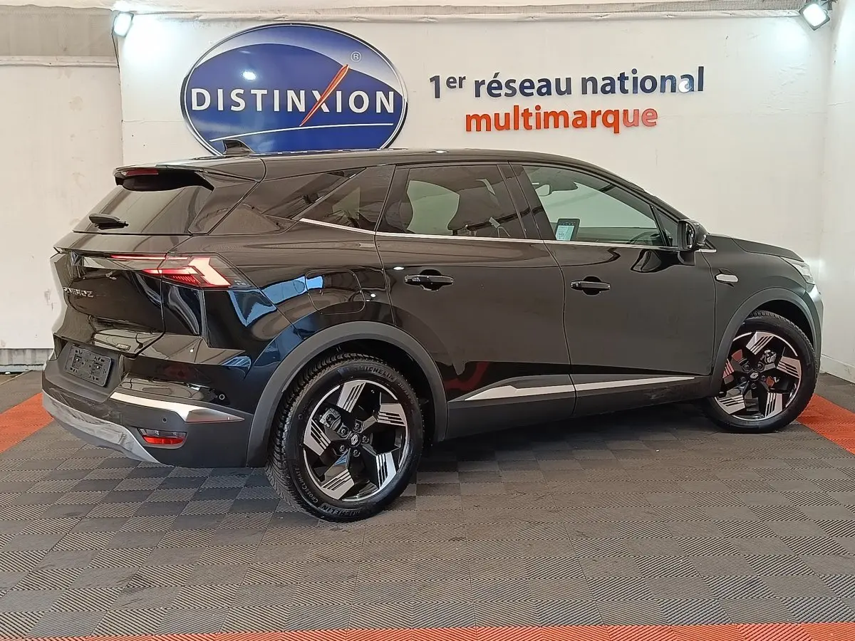 Renault Symbioz Iconic E-Tech 145 noir, vue profil droit en intérieur avec jantes stylisées et feux arrière LED distinctifs.
