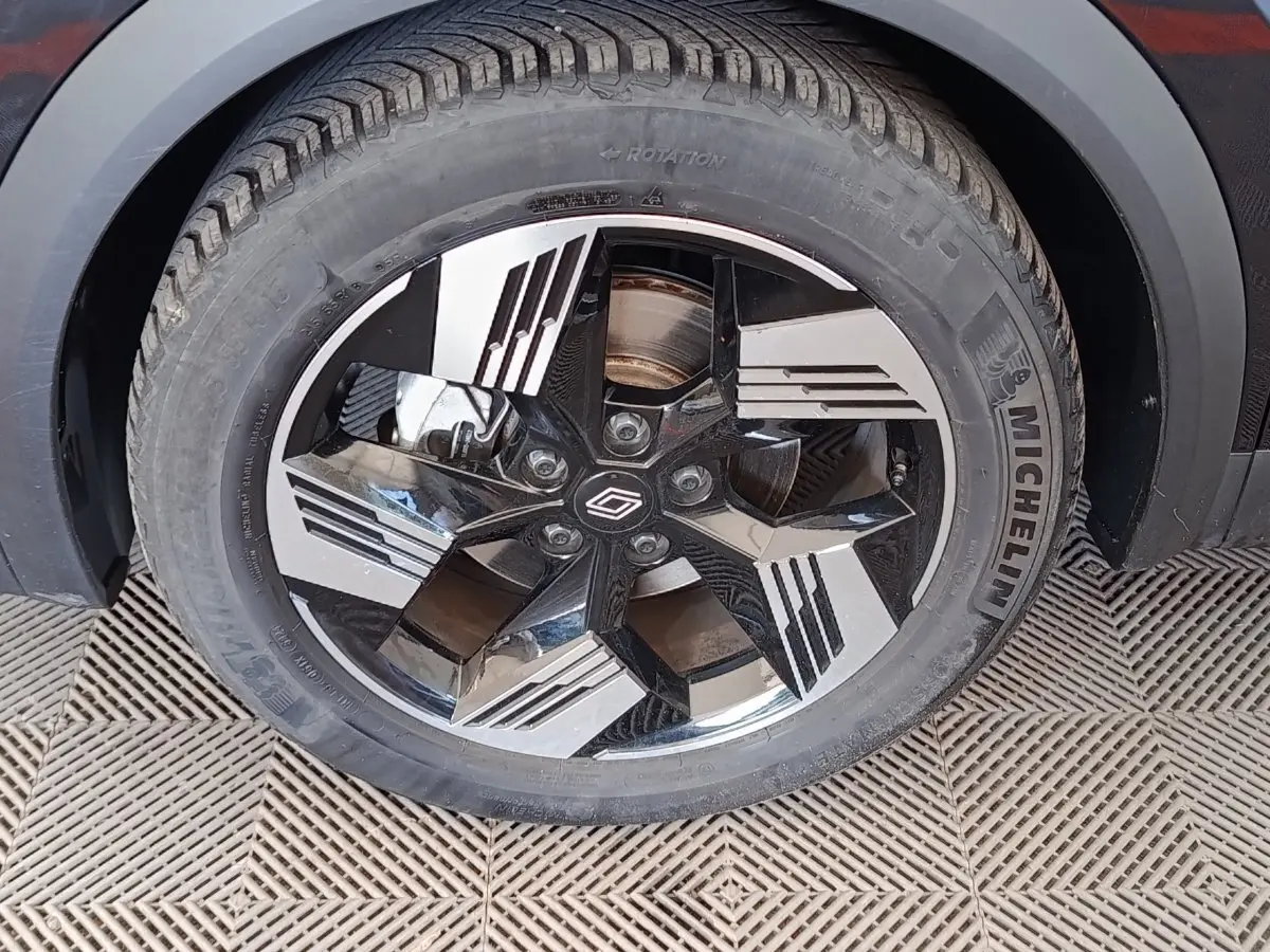 Gros plan sur la roue avant droite noire avec jante diamantée du Renault Symbioz Iconic E-Tech hybride 2025.