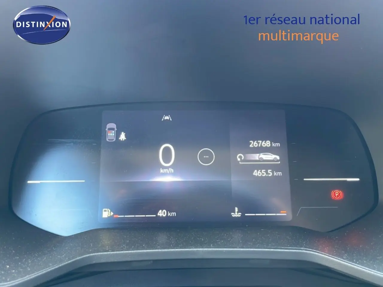 Tableau de bord numérique de Renault Clio rouge flamme, affichant 0 km/h et 26 768 km au compteur.