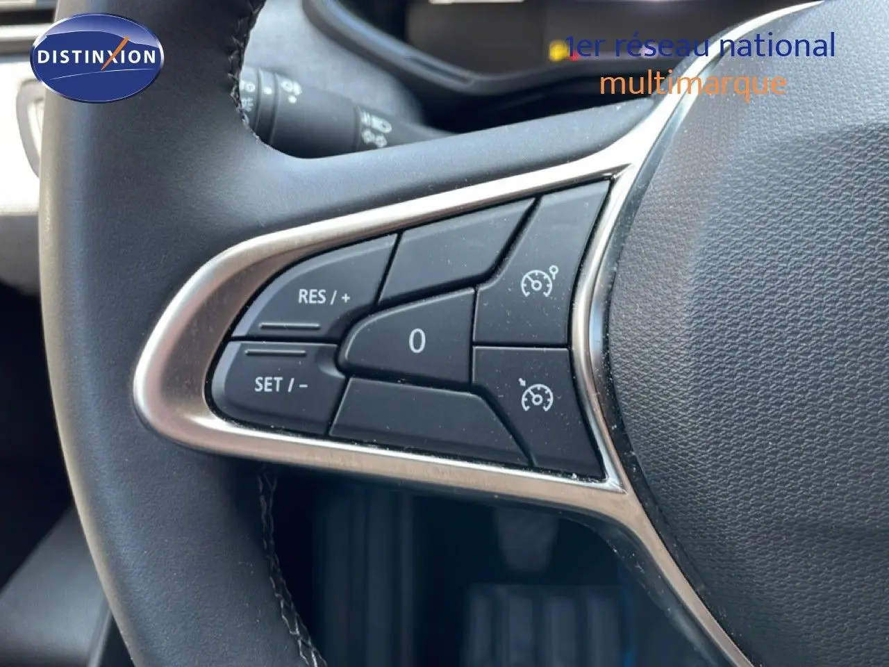 Gros plan sur les commandes de régulateur de vitesse au volant noir de la Renault Clio V BluedCi 2025.