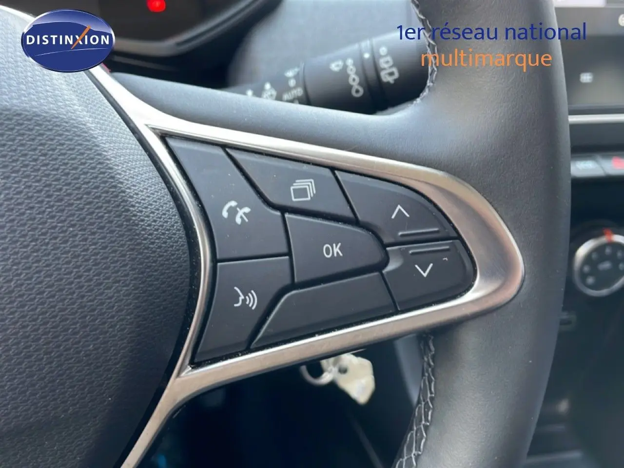 Gros plan sur les commandes au volant en cuir noir de la Renault Clio 2025, avec boutons multifonctions et finition argentée.