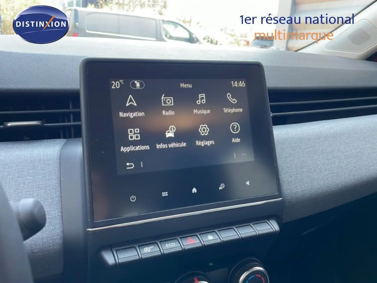 Vue intérieure du tableau de bord de la Renault Clio rouge flamme, écran tactile central avec commandes climatisation en dessous.