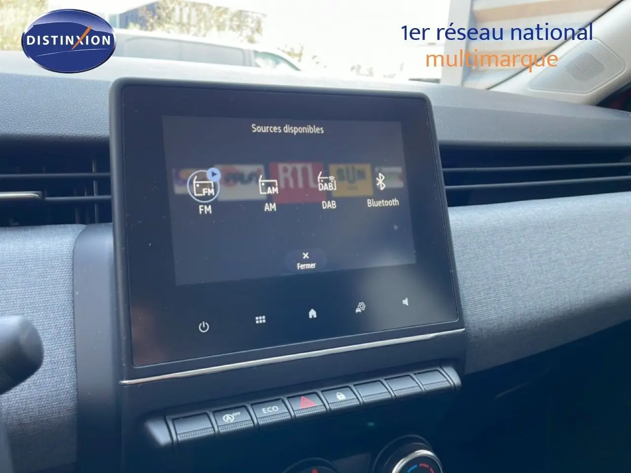 Vue intérieure du tableau de bord de la Renault Clio 2025, avec écran tactile central et commandes climatisation visibles.