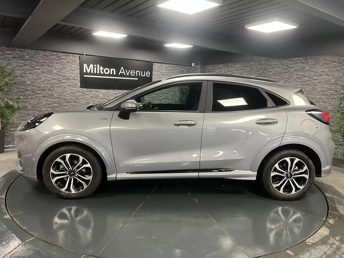Ford Puma gris Solar en vue profil côté gauche, avec barres de toit noires et jantes alliage 17 pouces.